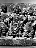 Maitreya bodhisattva, standing, in abhayamudra, with male and female figures